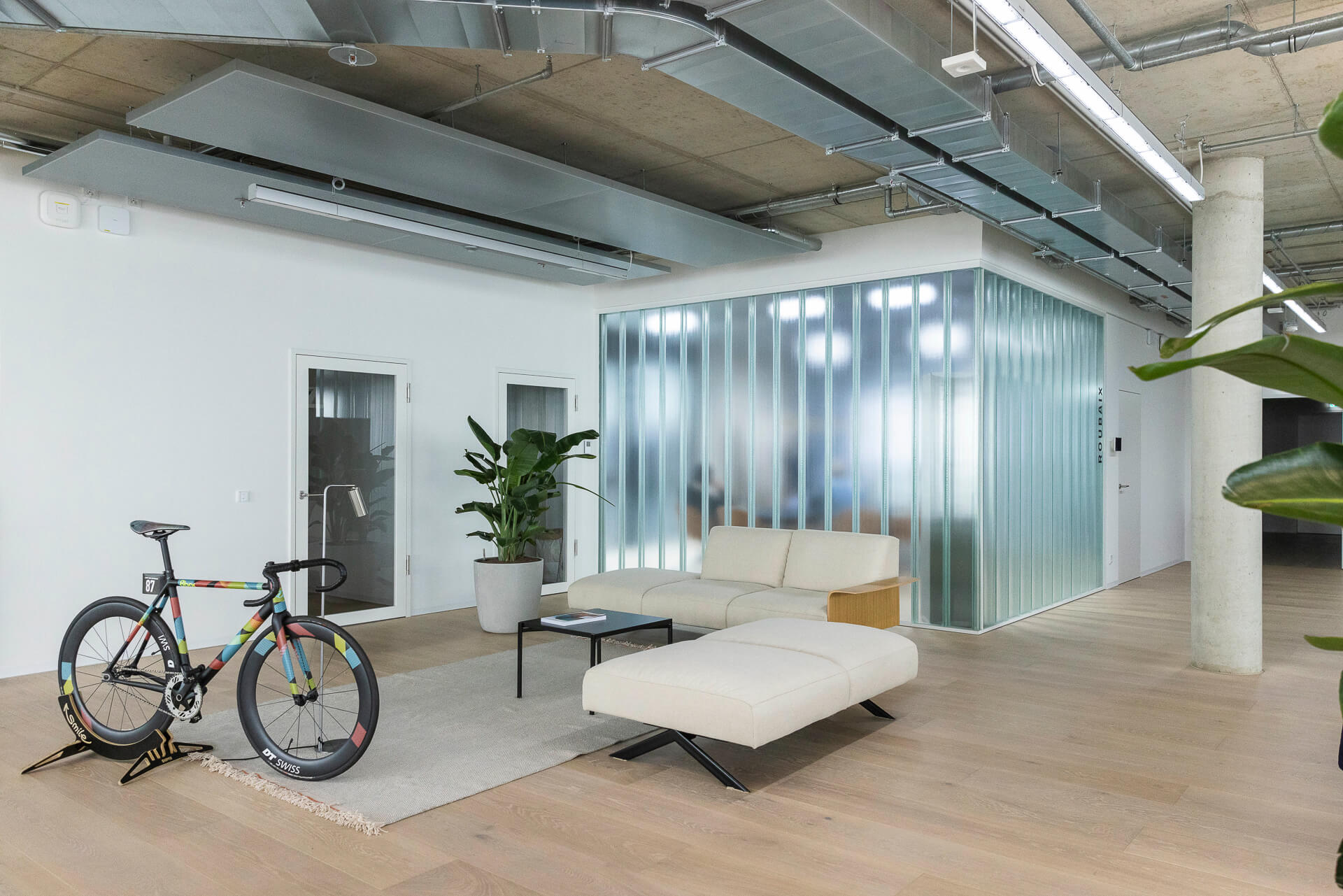 kundenreferenz-bos-schwalbe-bakb-007 Lounge-Bereich der Firma Schwalbe mit dekorativem Fahrrad und Glaskasten im Hintergrund