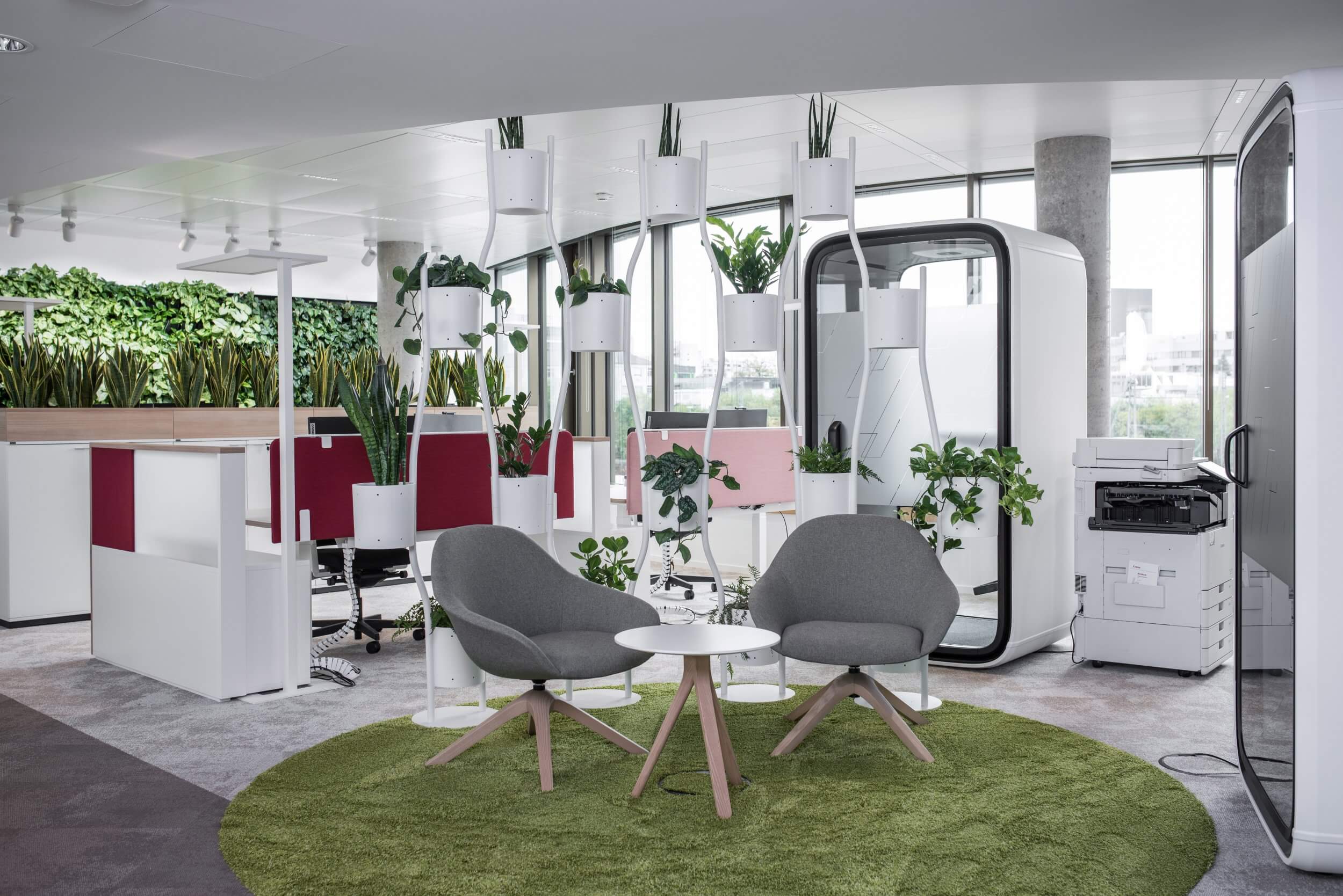 Arbeitsort der Firma Noventi Health SE mit Sesseln, Schreibtischen und Telefonkabine